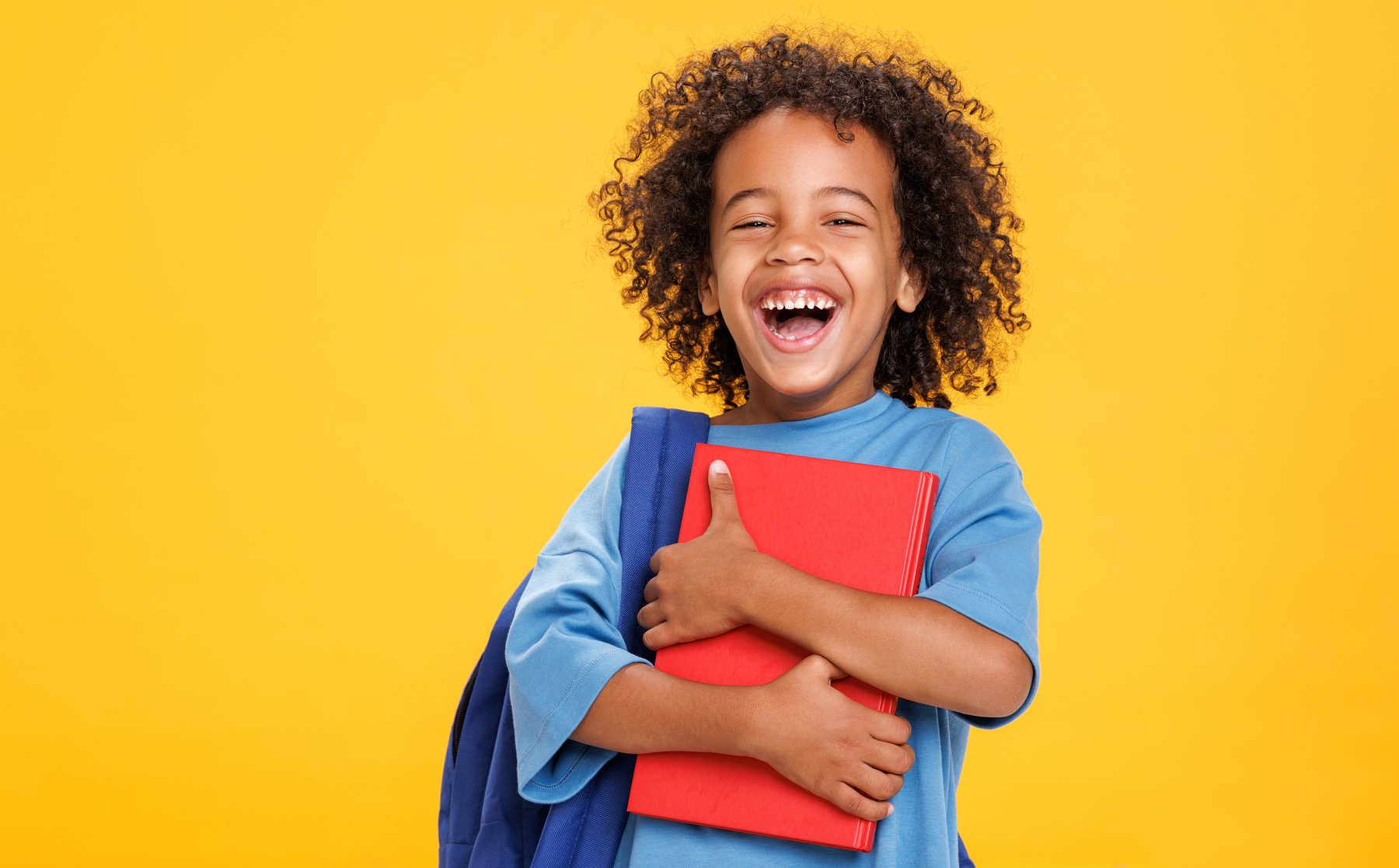 A smiling student holding a notebook.